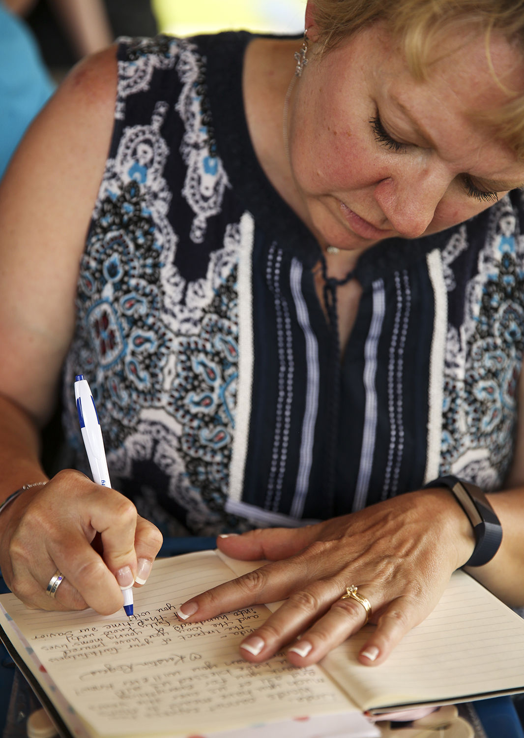 Roxanne Hulick writes a short message for Linda in a book the group